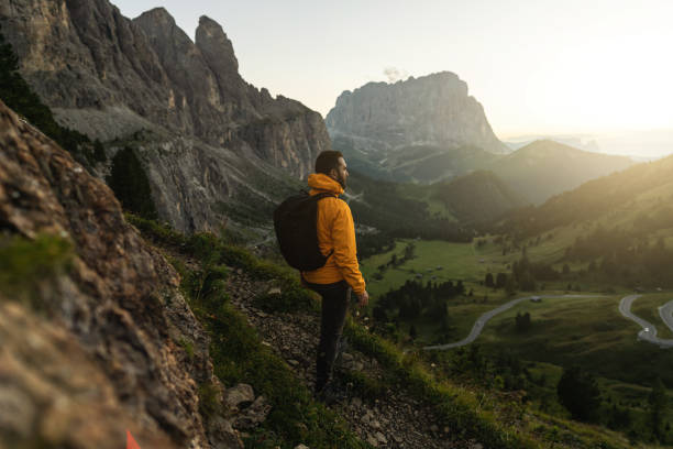 Man mountain hiking at sunset on the Dolomites: post pandemic outdoor adventure Mission